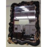 An Oriental inspired ebonised and gilt decorated wall mirror
