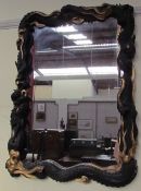 An Oriental inspired ebonised and gilt decorated wall mirror