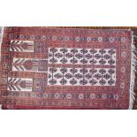 A pale red ground rug, with five rectangular panels and multiple guard stripes,