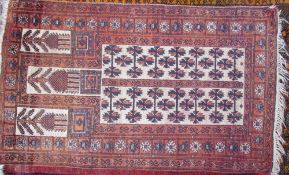 A pale red ground rug, with five rectangular panels and multiple guard stripes,