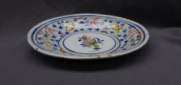 A Majolica charger, painted to the edge with flowerheads and leaves, the centre painted with fruit,