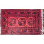 A red ground rug with three central medallions to multiple guard stripes,