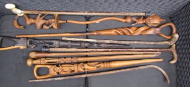 Assorted carved African and other walking sticks,