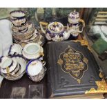 A leather bound bible together with a floral decorated part tea service