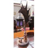A continental moose antler table lamp with carved lamp lighter and dog