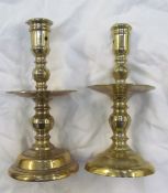 A 17th century style brass candlestick with central drip pan on a spreading foot,