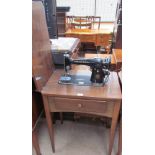 A Singer sewing machine and table with a base drawer and four tapering legs