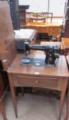 A Singer sewing machine and table with a base drawer and four tapering legs