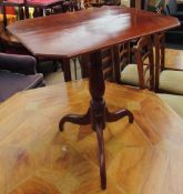 A 19th century mahogany tripod table with a rectangular top with cut corners on a ring turned
