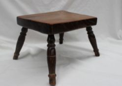 A 19th century Elm seated milking stool, the rectangular top on four splayed turned legs,