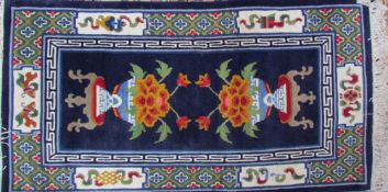 Two Tibetan rugs, one with opposing vases of flowers,