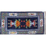 Two Tibetan rugs, one with opposing vases of flowers,