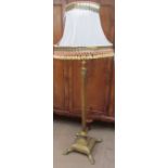 A 20th century brass corinthian column standard lamp on a square base with lions paw feet