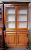 A Victorian oak bookcase with a moulded cornice above a pair of glazed doors,