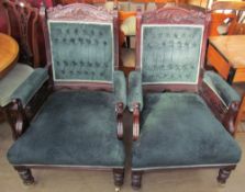 A pair of Edwardian upholstered library chairs with a carved cresting rail,