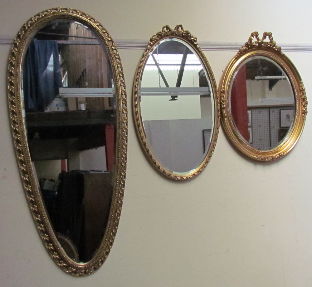 A gilt tear drop shaped wall mirror together with two other gilt decorated wall mirrors
