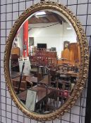 An oval gilt wall mirror together with a collection of mirrors and a photograph