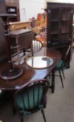 A 20th century oak gateleg dining table together with a set of four stick back chairs,