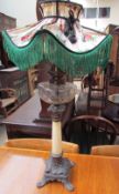 A Victorian oil lamp with a cut glass reservoir on a tapering marble column and cast metal