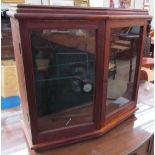 A wall hanging display cabinet with glazed doors