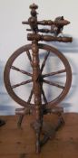 A large fruitwood spinning wheel with turned spindles together with a small fruitwood spinning