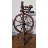 A large fruitwood spinning wheel with turned spindles together with a small fruitwood spinning