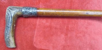 An antler handled walking stick with a silver collar