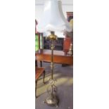 A Victorian brass converted standard lamp with raised flowerhead and leaves the base circular base