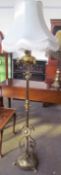 A Victorian brass converted standard lamp with raised flowerhead and leaves the base circular base