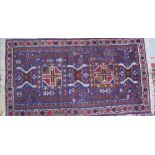 A blue ground rug, with central medallions and geometric decoration,