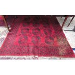 A large red ground rug with eighteen geometric guls and broad guard stripes