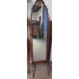 A 20th century walnut cheval mirror with an arched top on splayed legs