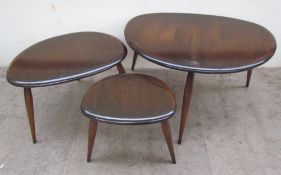 An Ercol pebble nest of three dark elm and beech tables