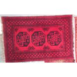 A red ground rug with three geometric guls