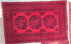 A red ground rug with three geometric guls