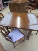 A 20th century oak extending dining table together with four chairs and a sideboard