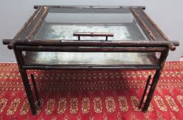 A bamboo bijouterie table with a glazed top and sides on four legs