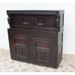 An 18th century oak court cupboard, the planked top above a carved frieze and turned columns,