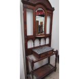 An Edwardian oak hall stand with a central mirror shelf, hook,