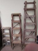 Three wooden step ladders