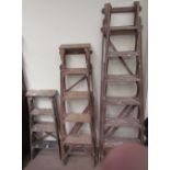 Three wooden step ladders