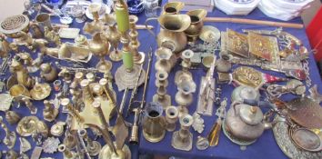 A large quantity of brass wares including jugs, candlesticks, photograph frames, fireside tidy,