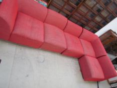 A modular red upholstered settee in five sections