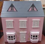 A pink doll's house together with doll's house furniture