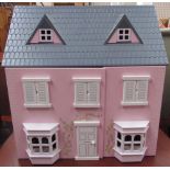 A pink doll's house together with doll's house furniture