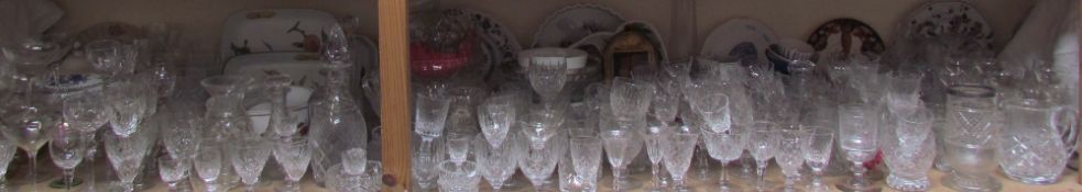 Assorted crystal drinking glasses together with glass jugs, decanters, pottery plates,