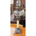 A Victorian oil lamp with a cut glass reservoir on a tapering marble column and cast metal base