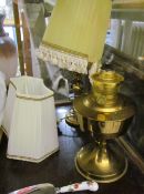 A brass oil lamp together with another table lamp