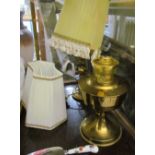 A brass oil lamp together with another table lamp