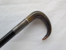 An ebonised walking stick with a silver collar and horn handle